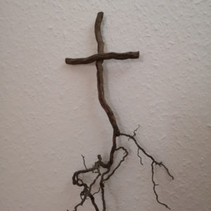 Kreuz aus Zweigen mit einer Wurzel unten